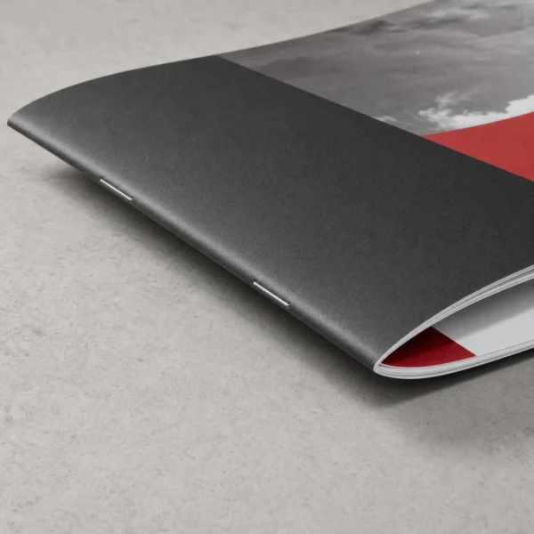 Close-up of saddle-stitch booklet binding and layered printed paper