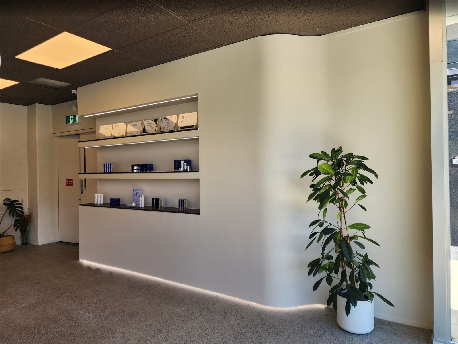 Curved retail display wall with integrated lighting inside JP MediSpa Auckland
